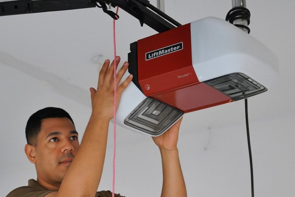 Technician performing a garage door tune-up, inspecting the door mechanism and opener system for smooth operation and safety.